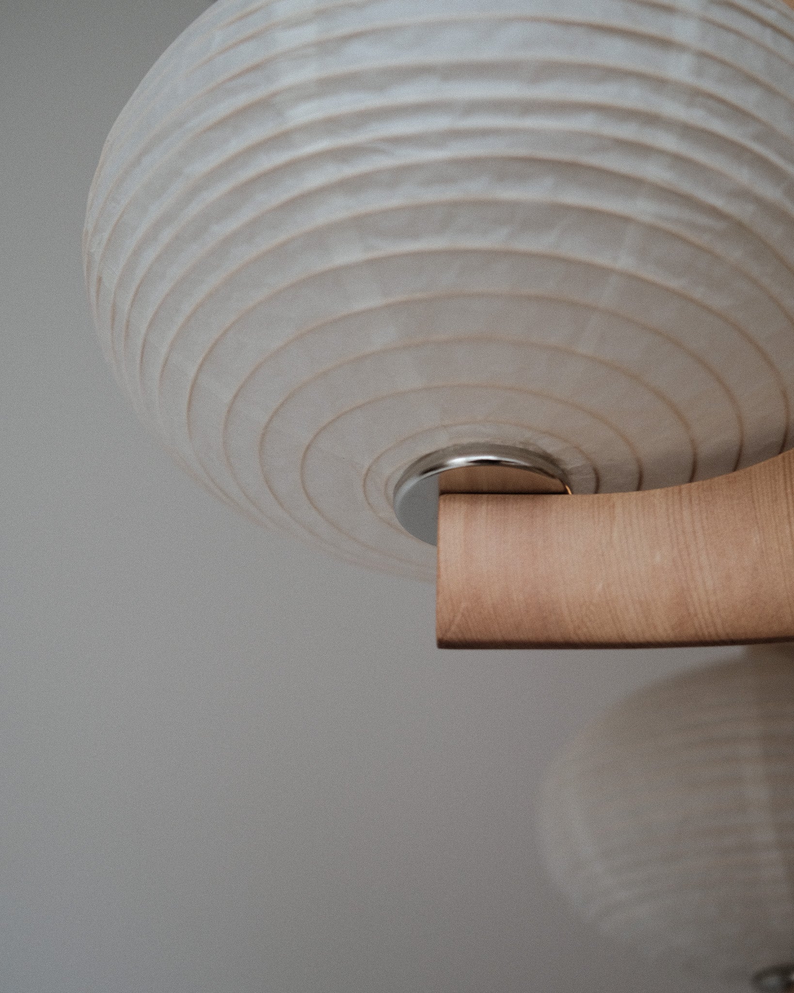 A detail shot of Kawabi's Cascade Pendant made of White Oak and kozo paper, focusing on the paper shade hardware.