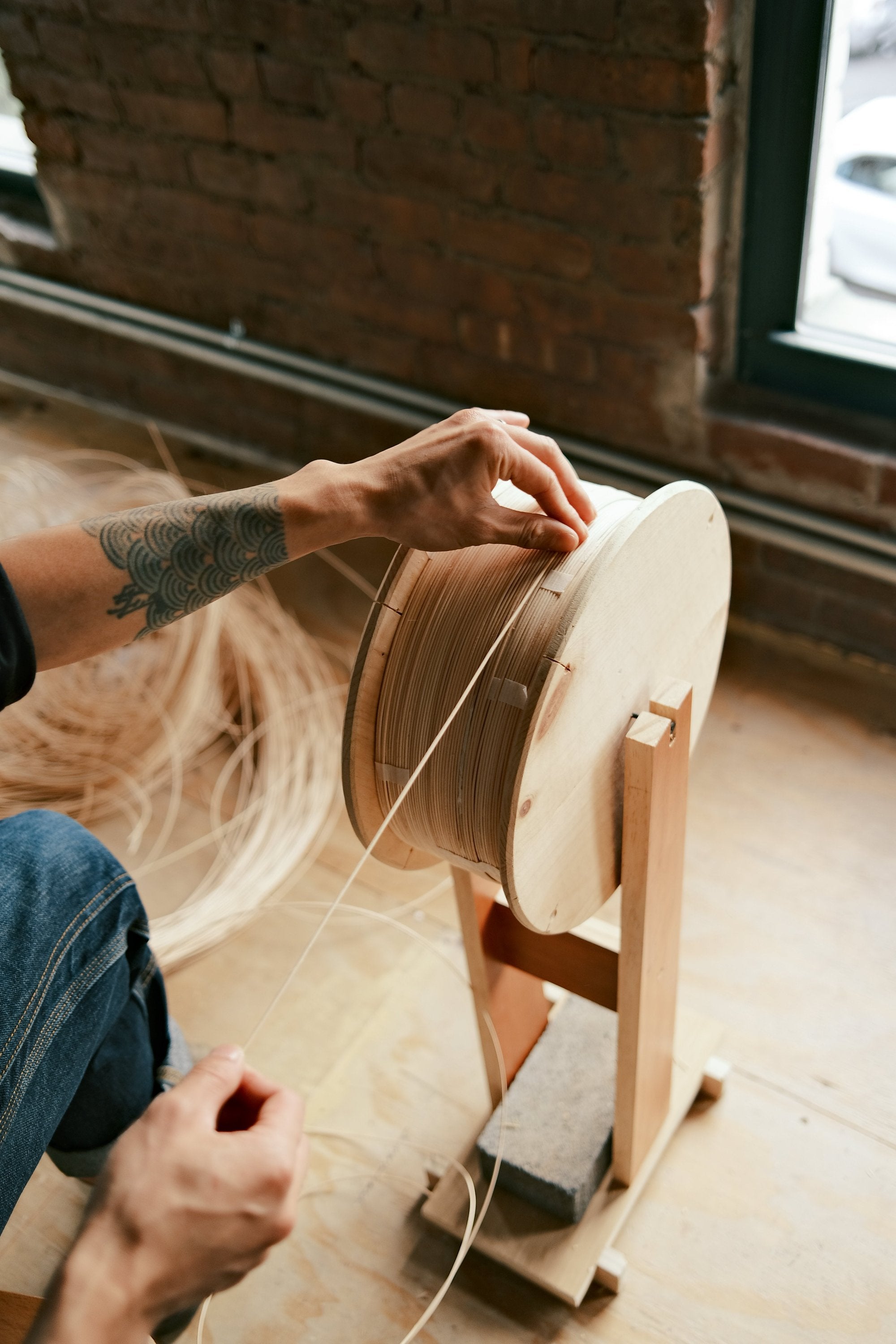 Aaron Kawabi in the middle of spooling reed in their Brooklyn-based studio