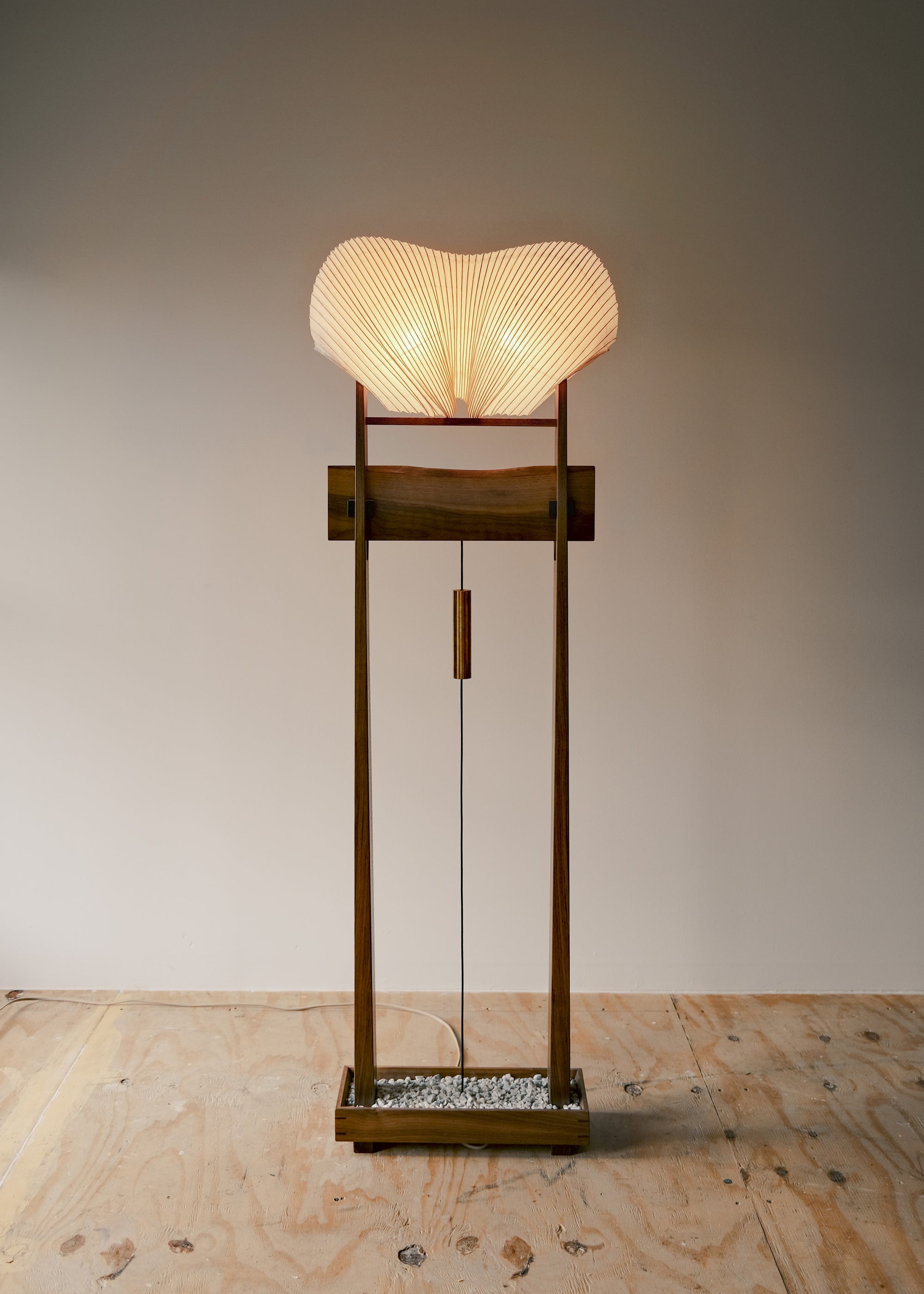 A front view image of Kawabi's Souvenir Floor Lamp lit up against a white background in their studio