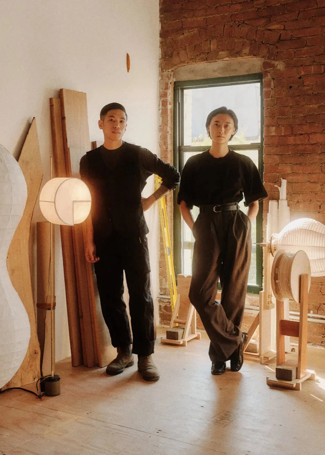 The lighting designers Aaron and Irisa Na Kawabi, photographed at their Brooklyn studio on Oct. 11, 2024, surrounded by works in progress